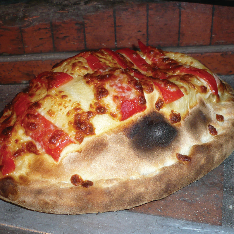 A robust calzone loaded with four varieties of cured and cooked meats, ham, pepperoni, sausage, and meatball, bound together with mozzarella and tomato sauce.