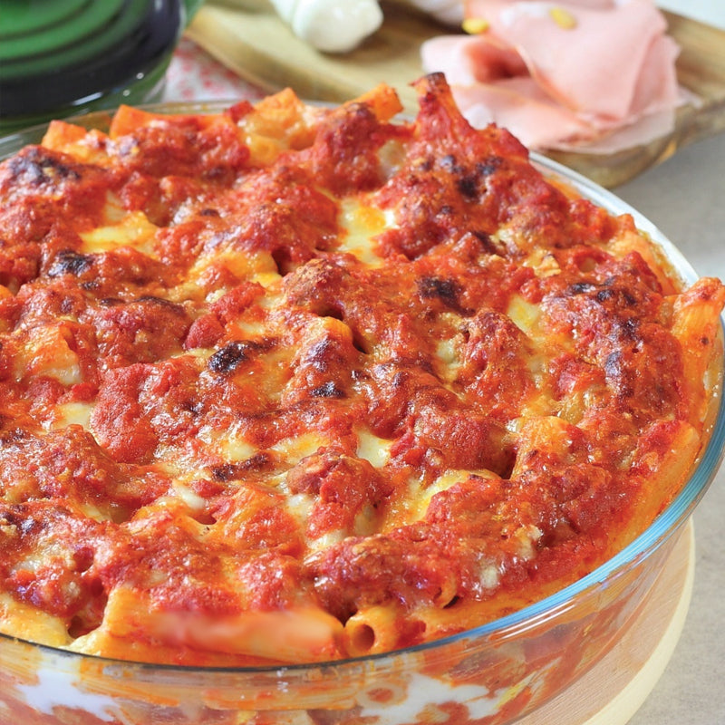 baked ziti Pasta dish with red sauce in a glass dish on a wooden table
