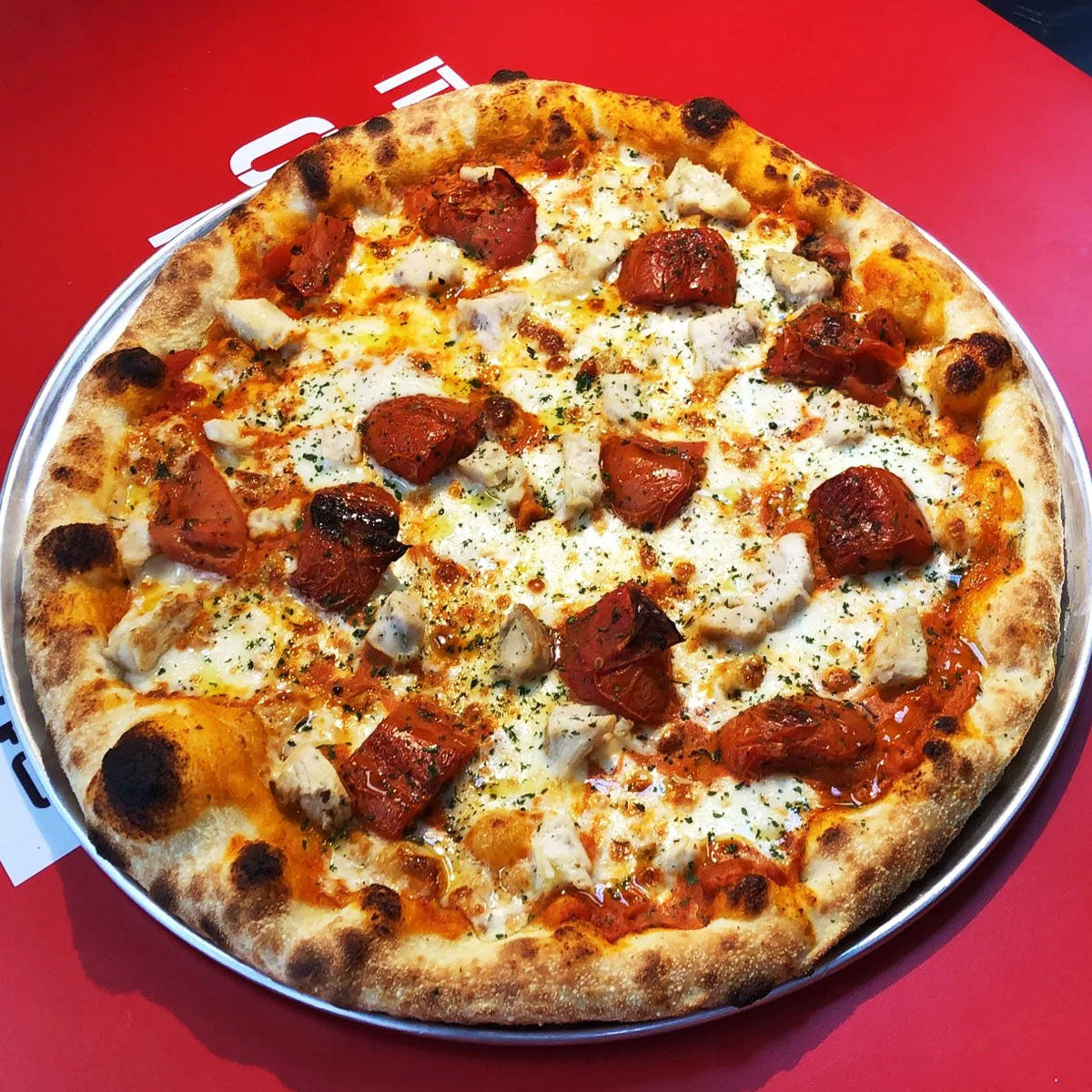 A 16-inch pizza that marries creamy vodka sauce with tender chicken for sophisticated depth. Tomato sauce provides the base, while mozzarella melts into the vodka cream, creating a luxurious, velvety foundation. Seasoned chicken adds protein and savory substance, finished with oregano's warm, earthy notes.