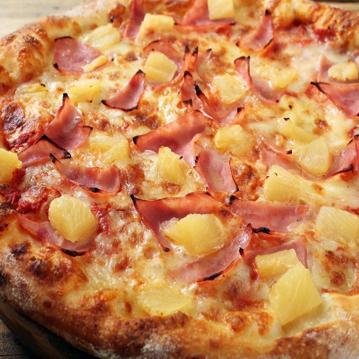Close-up of a pizza with ham and pineapple toppings