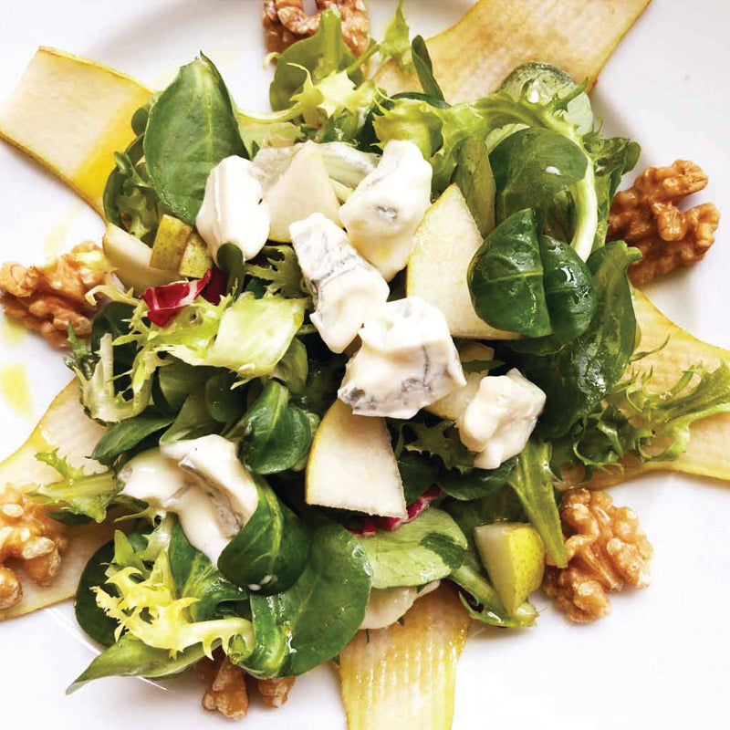 Italian Catering  Salad with greens, pears, gorgonzola and walnuts on a white plate
