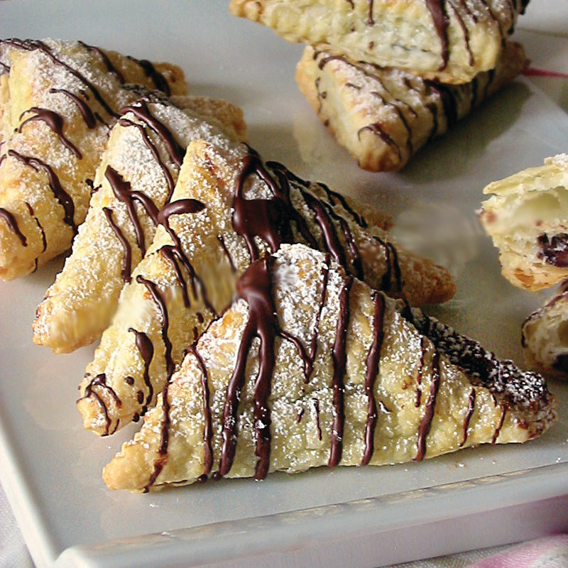 Nutella Triangular pastries with chocolate drizzle on a white plate