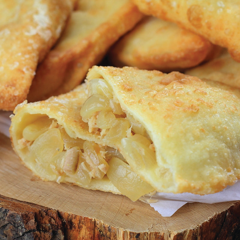 panzerotto with Flaky tuna pairs with creamy mozzarella, sweet caramelized onions, briny capers, and juicy cherry tomatoes in a golden-fried pastry shell